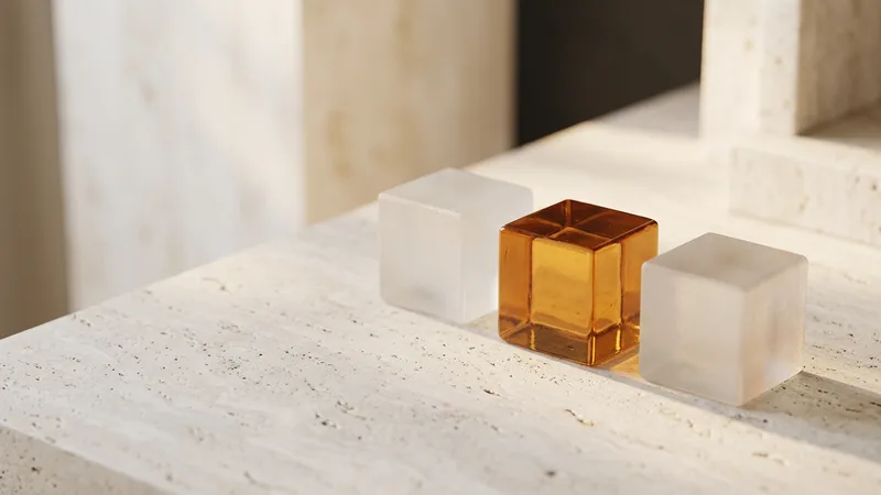 Three identical frosted-glass blocks with one amber block among them, representing franchise network intangible assets becoming visible unit by unit